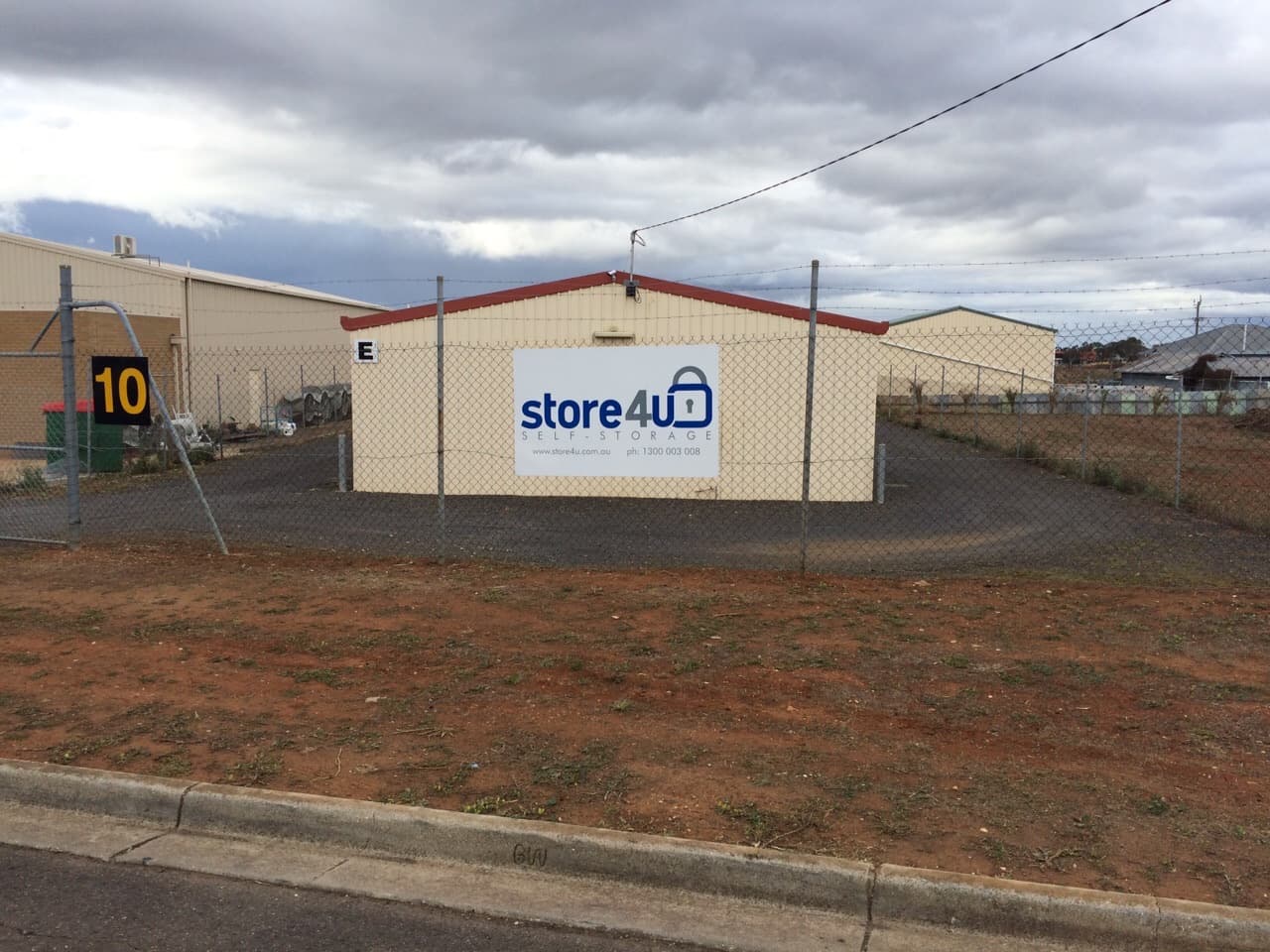10 Smith Street from the street: E block behind the fence, with the Store 4 U sign